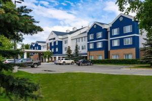 un grand bâtiment bleu avec des voitures garées dans un parking dans l'établissement SpringHill Suites Anchorage Midtown, à Anchorage