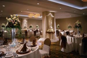 - une salle de banquet avec des tables blanches, des chaises et des fleurs dans l'établissement Courtyard Los Angeles Sherman Oaks, à Sherman Oaks