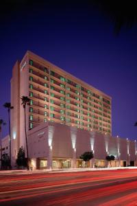 un grand bâtiment d'hôtel avec des palmiers devant lui dans l'établissement Courtyard Los Angeles Sherman Oaks, à Sherman Oaks