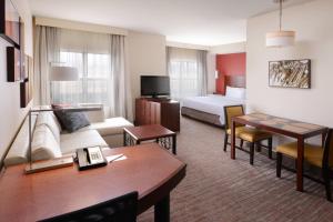a hotel room with a bed and a living room at Residence Inn by Marriott Dallas Plano The Colony in The Colony