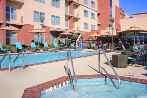 a swimming pool at a hotel with chairs and umbrellas at Residence Inn by Marriott Dallas Plano The Colony in The Colony