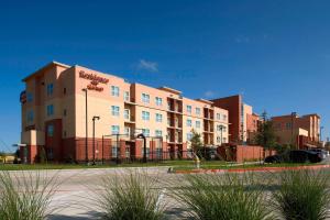 a large apartment building in front of a parking lot at Residence Inn by Marriott Dallas Plano The Colony in The Colony