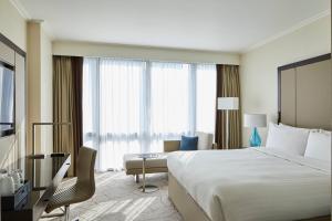 a hotel room with a large bed and a chair at London Marriott Hotel Canary Wharf in London