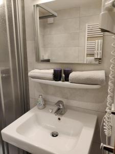 een badkamer met een wastafel, een spiegel en handdoeken bij Alt Reinsport in Piesport