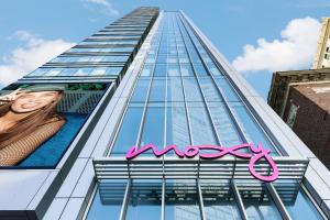 een hoog gebouw met een roze bord erop bij Moxy Boston Downtown in Boston