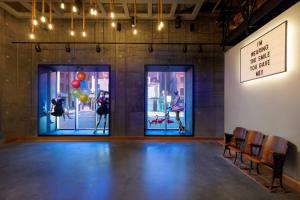 a room with a stage with three doors and chairs at Moxy Boston Downtown in Boston