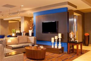 a living room with a couch and a flat screen tv at Courtyard Hartford Manchester in Manchester