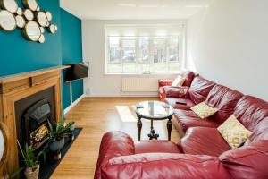 a living room with a red leather couch and a fireplace at Delightful Stay For 2 in Islington in London