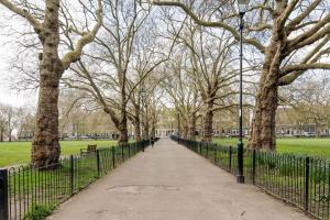 uma passarela num parque com árvores e uma cerca em Delightful Stay For 2 in Islington em Londres