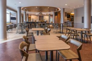 a restaurant with tables and chairs and a bar at SpringHill Suites by Marriott Huntsville Downtown in Huntsville