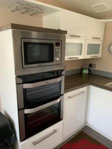 a kitchen with a microwave and a stove at Meridian Lodge in Great Billing