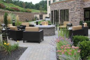 a patio with chairs and a fire pit in a garden at Courtyard by Marriott Oneonta in Oneonta