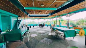 een restaurant met tafels en stoelen en een trap bij Emshienell Beach Resort and Event Place in Zambales