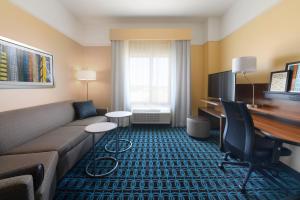 a living room with a couch and a desk in a hotel room at Fairfield Inn & Suites by Marriott Fort Worth South/Burleson in Burleson