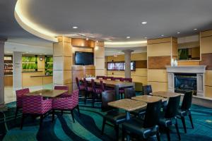 a restaurant with tables and chairs and a fireplace at SpringHill Suites by Marriott Medford in Medford