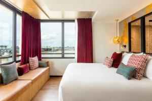 ボルドーにあるRenaissance Bordeaux Hotelのベッドと大きな窓が備わるホテルルームです。