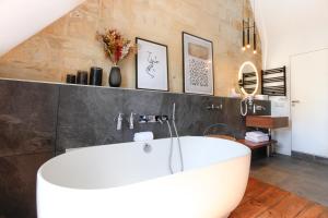 La salle de bains est pourvue d'une baignoire blanche. dans l'établissement Maison Labruyère Bordeaux - Jardin Public, à Bordeaux