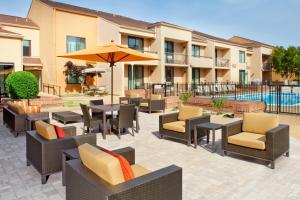 a patio with tables and chairs and an umbrella at Courtyard by Marriott Columbus in Columbus
