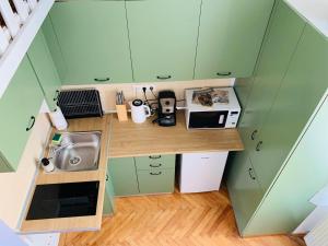 クルジュ・ナポカにあるCentral Cozy Apartmentの小さなキッチン(緑のキャビネット付)のオーバーヘッドビュー