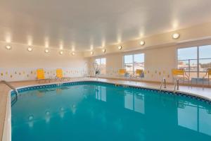 uma grande piscina num quarto de hotel com cadeiras em Fairfield Inn & Suites Longview em Longview