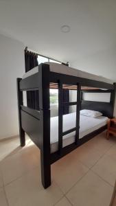 a black bunk bed sitting in a room at Arboleda Real Hospedaje in Armenia