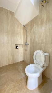La salle de bains est pourvue d'une douche et de toilettes. dans l'établissement The Pinasti Villas, à Tlekung