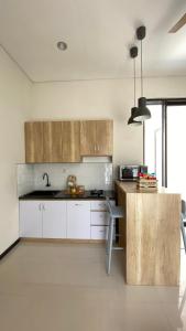 a kitchen with white cabinets and a sink and a counter at The Pinasti Villas in Tlekung