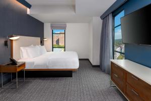 pokój hotelowy z łóżkiem i dużym oknem w obiekcie Courtyard by Marriott Atlanta Midtown w Atlancie