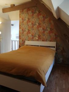 ein Schlafzimmer mit einem Bett mit einer orangefarbenen Decke in der Unterkunft Mer&Campagne Wimille in Wimille