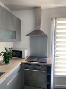 a kitchen with a stove and a microwave at Petite maison au bord de la forêt 