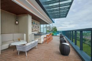 a patio with a table and chairs on a balcony at Courtyard by Marriott Setia Alam in Setia Alam