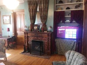 a living room with a fireplace and a tv at Historic Victorian Inn in Sioux Falls