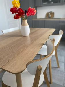 a wooden table with a vase of flowers on it at Petite maison au bord de la forêt 