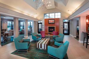 a lobby with blue chairs and a fireplace at Residence Inn Dover in Dover