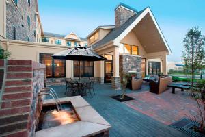 un patio extérieur avec un parasol et une fontaine dans l'établissement Residence Inn Dover, à Dover