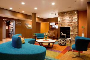 a waiting room with blue chairs and a fireplace at Fairfield Inn and Suites by Marriott Cincinnati Eastgate in Eastgate