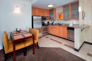 cocina con mesa de madera y nevera en Residence Inn Dover, en Dover