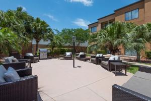 a patio with chairs and tables in front of a building at Courtyard Harlingen in Harlingen