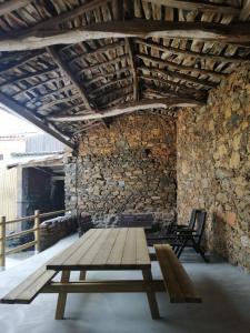 Cette chambre est dotée d'un banc en bois et d'un mur en pierre. dans l'établissement Casa Carlán, à Melide