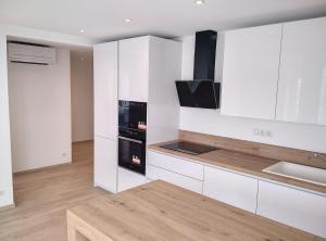 kuchnia z białymi szafkami i kuchenką w obiekcie Résidence Graziella Appartement 621 w mieście Juan-les-Pins