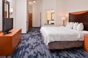 a hotel room with a bed and a flat screen tv at Fairfield Inn and Suites by Marriott Birmingham Pelham/I-65 in Pelham