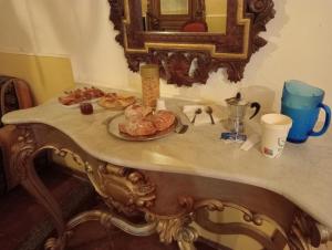 stół z dwoma talerzami wypieków i lustrem w obiekcie Baron'sRoom w mieście Nocera Inferiore