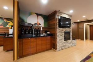 a room with a bar with a fireplace and a tv at Fairfield Inn Orangeburg in Orangeburg