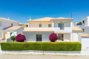une maison blanche avec des fleurs roses devant elle dans l'établissement Casa do Topo Guesthouse, à Lagos 24 autres photos