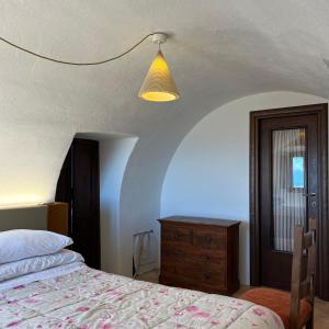 een slaapkamer met een bed, een dressoir en een lamp bij La Taberna di Rocca Calascio in Calascio