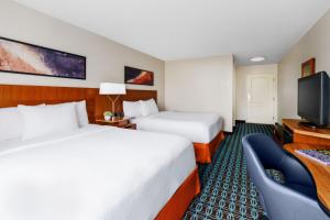 a hotel room with two beds and a flat screen tv at Fairfield Inn and Suites by Marriott Houston The Woodlands in The Woodlands