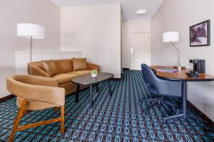 a hotel room with a couch and a table and a desk at Fairfield Inn and Suites by Marriott Houston The Woodlands in The Woodlands
