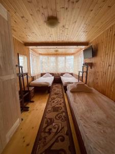 a room with three beds and a rug at Made in Yaremche in Yaremche