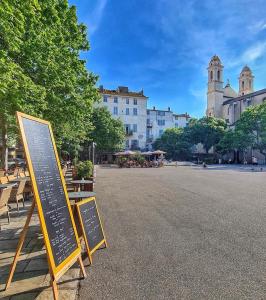 a sign in the middle of a street with a building at Pépite Bastiaise Place du Marché in Bastia