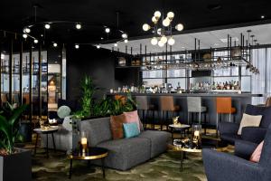 a restaurant with couches and tables and a bar at Renaissance Amsterdam Schiphol Airport Hotel in Schiphol